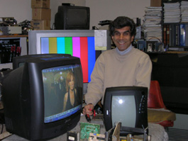 Al standing behind a television